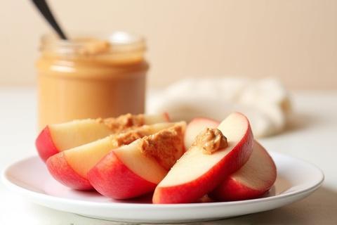 Sliced red apples with a dollop of peanut butter.